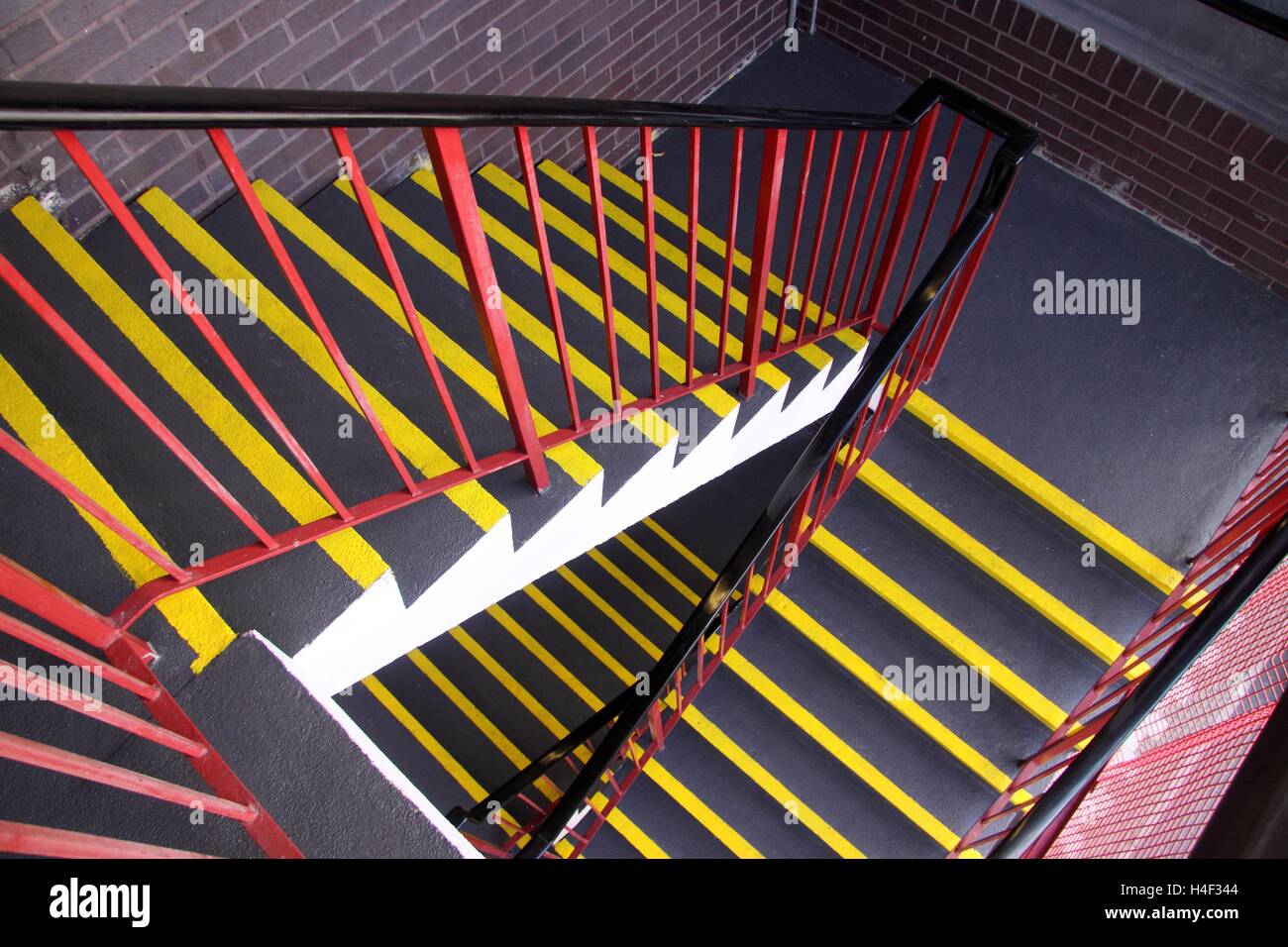 Blick nach unten eine Treppe mit fluoreszierenden Sicherheitsleisten gemalt am Rande eines jeden beschreiten. Stockfoto