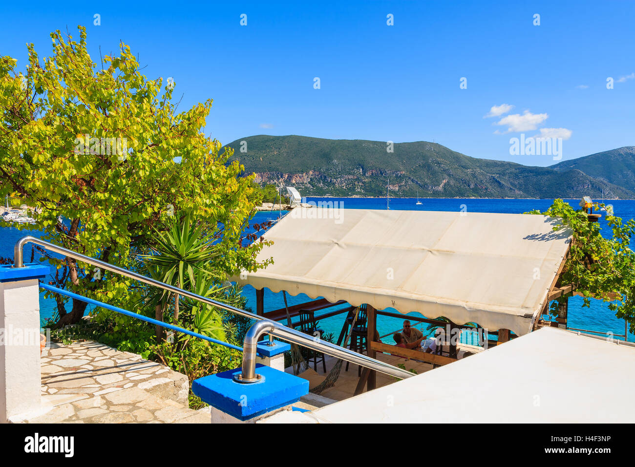 FISKARDO, KEFALONIA - SEP 18, 2014: Traditionelle griechische Taverne in Fiskardo Hafen, Insel Kefalonia, Griechenland. Griechenland ist bekannt für gutes Essen und sonniges Wetter. Stockfoto