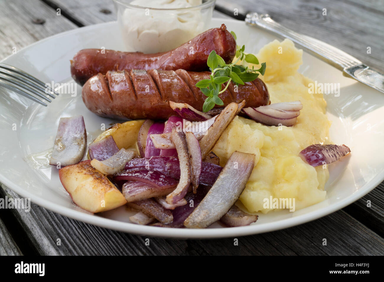 Traditionelle schwedische Mittagessen mit Würstchen, Kartoffelpüree, Apfel und Zwiebeln Stockfoto