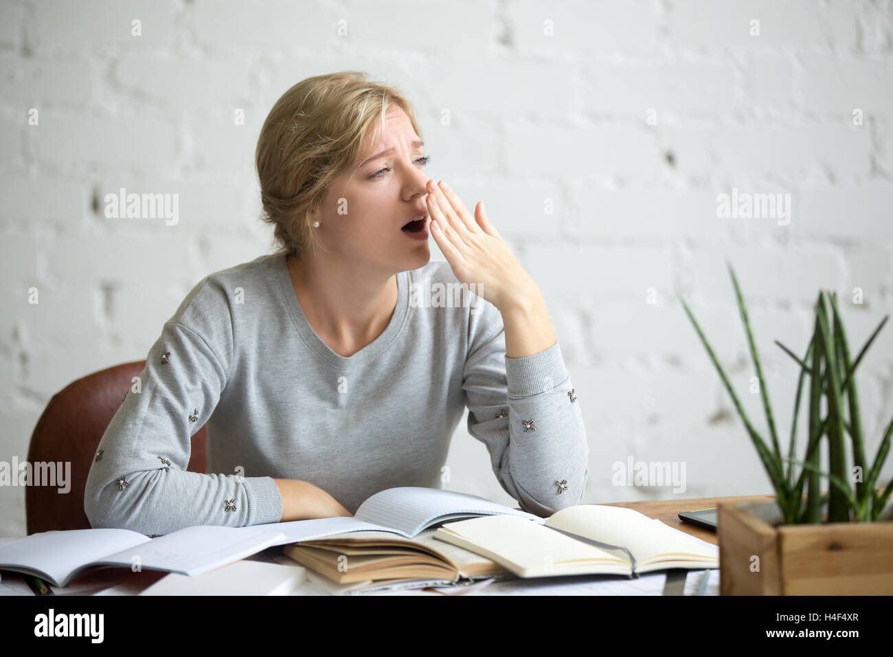 Porträt von einem gähnenden Studentin an der Rezeption Stockfoto