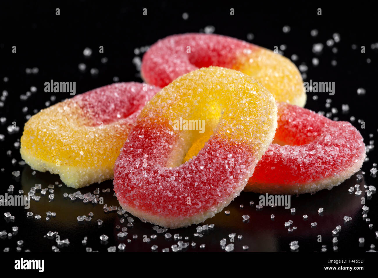 Gelee-Bonbons mit weißem Zucker auf schwarzem Hintergrund Stockfoto