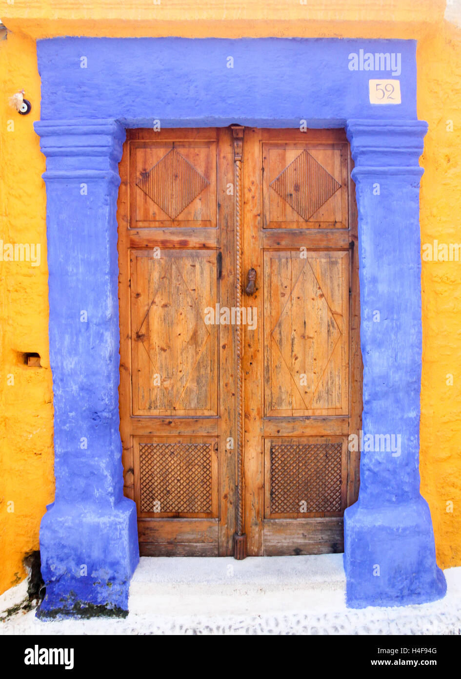 Doppeltüren mit blauen Surround gegen gelbe Wände Stockfoto
