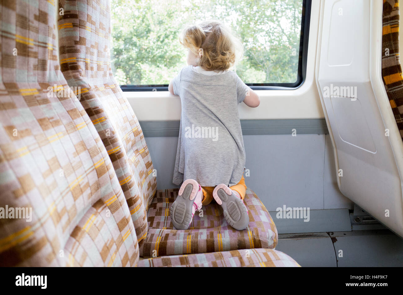 Kleines Kind von zwei Jahren, das in einem London Overground Zug, England, Großbritannien, unterwegs ist Stockfoto