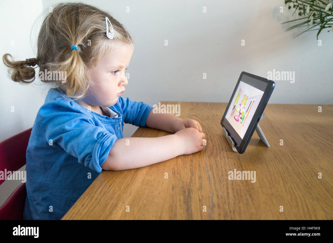 Zwei Jahre altes Kleinkind aufpassen cartoon Kinder auf Apple iPad, Großbritannien Stockfoto