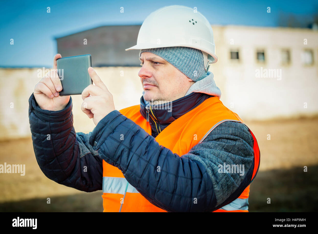 Ingenieur mit Tablet-PC in der Nähe von Gebäude gefilmt Stockfoto