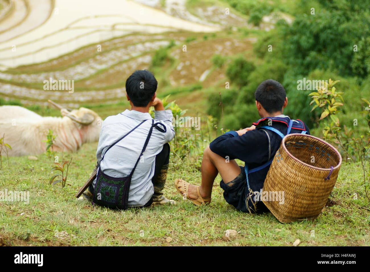 Zwei einheimische Jugendliche sitzen auf einem Hügel und sprechen. Sapa, Vietnam, Lao Cai Provinz Asien Stockfoto
