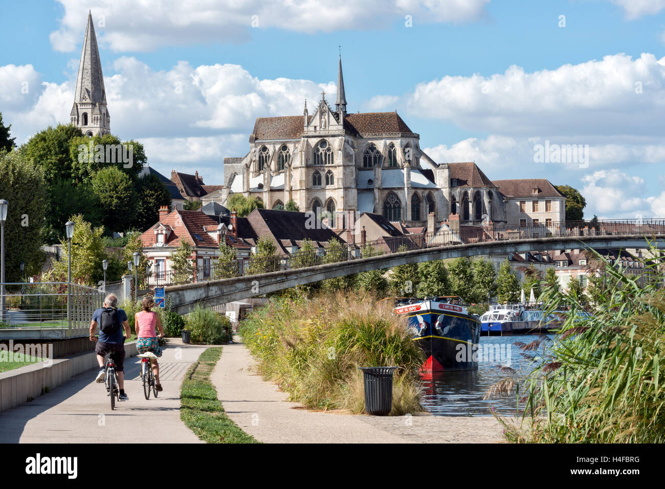 Besucher, die Radfahren in Richtung d'Auxerre der Abbaye de Saint-Germain in Auxerre auf dem Treidelpfad am Ufer des Flusses Yonne, Burgund, Frankreich Stockfoto