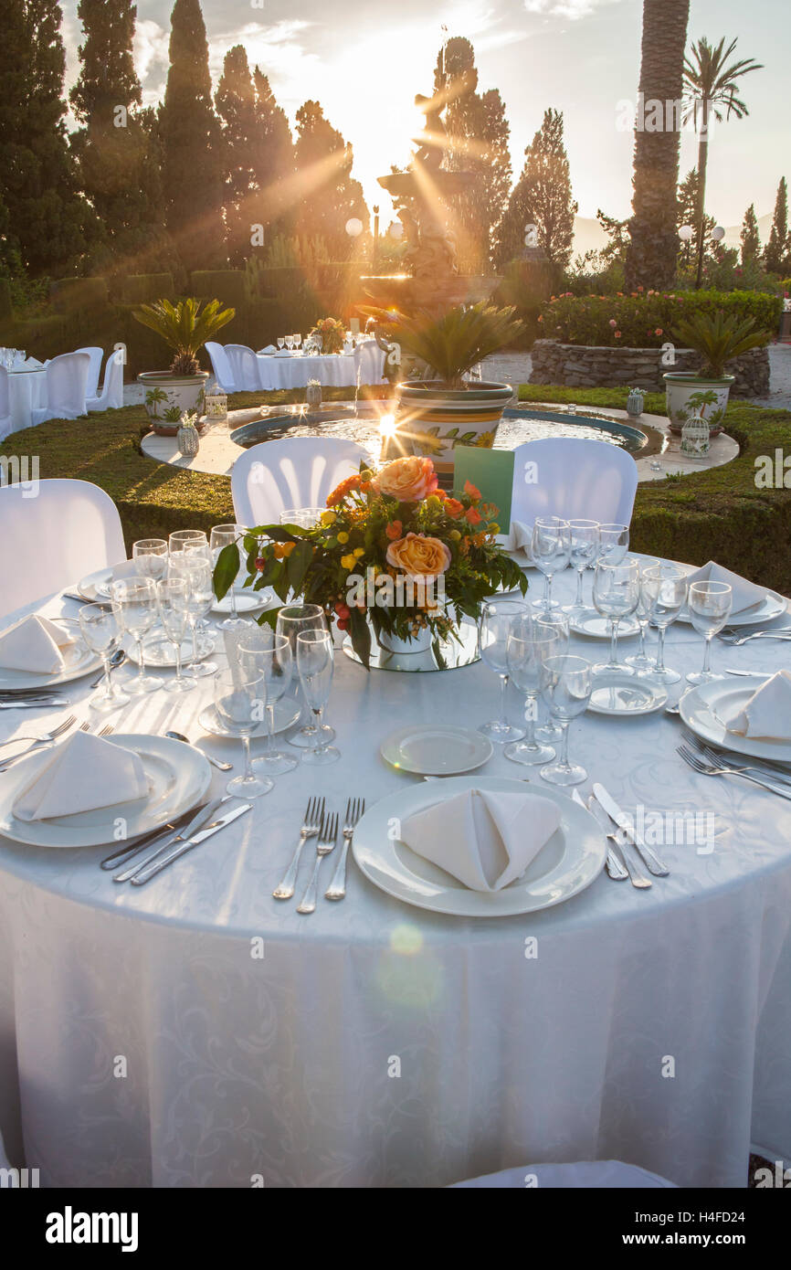 Gartentisch-Einstellung bei Hochzeitsfeier unter Sonnenuntergang Sonnenstrahlen Stockfoto