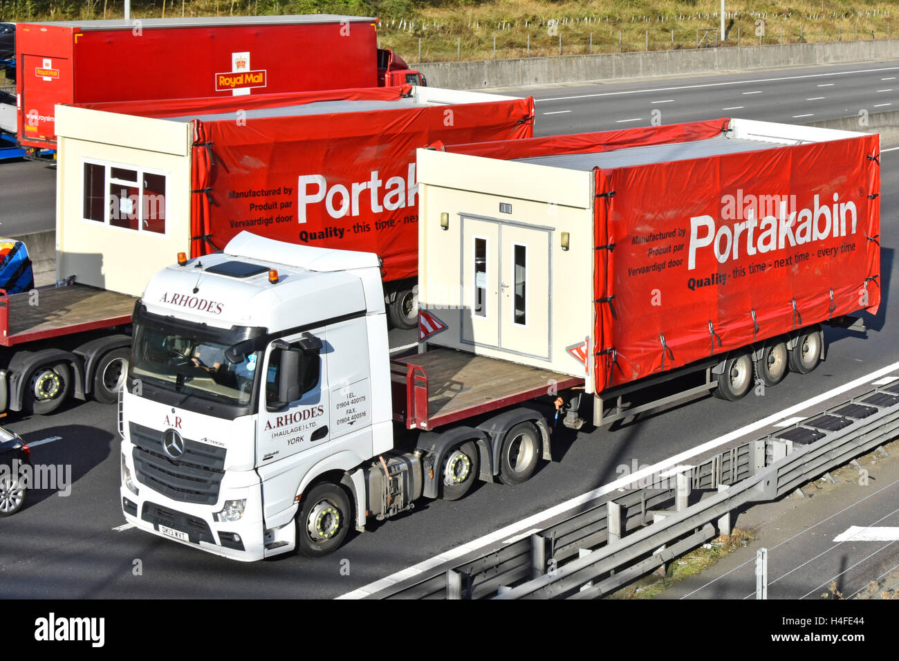 Lastkraftwagen mit Gelenkanhängern, die auf der Autobahn M25 UK in England Großbritannien im Stau stecken gebliebene tragbare Gebäudeteile transportieren Stockfoto