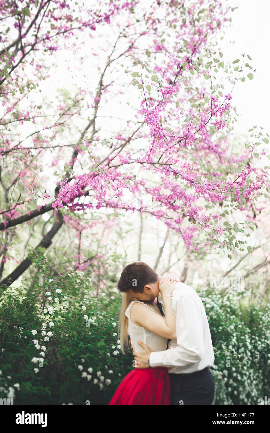 Stilvolle schöne glückliche Hochzeit paar küssen und umarmen im Botanischen Garten Stockfoto