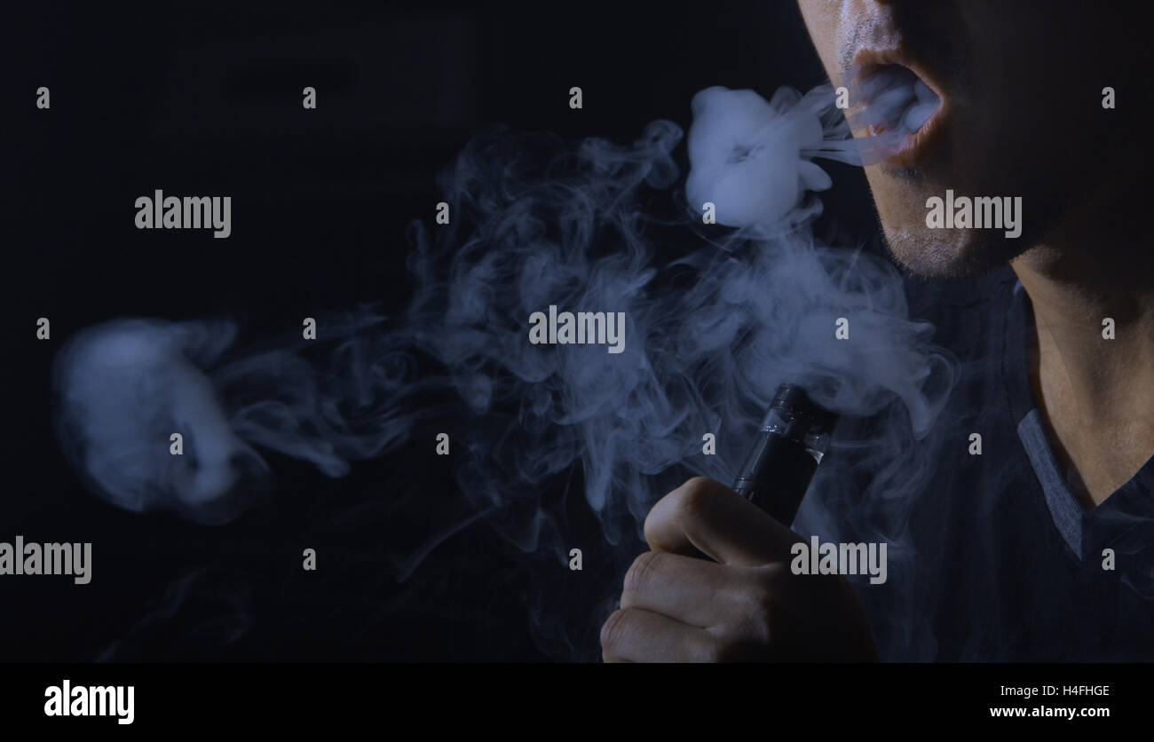 Mann rauchen elektronische Zigarette und machen Rauch Ringe Stockfotografie  - Alamy
