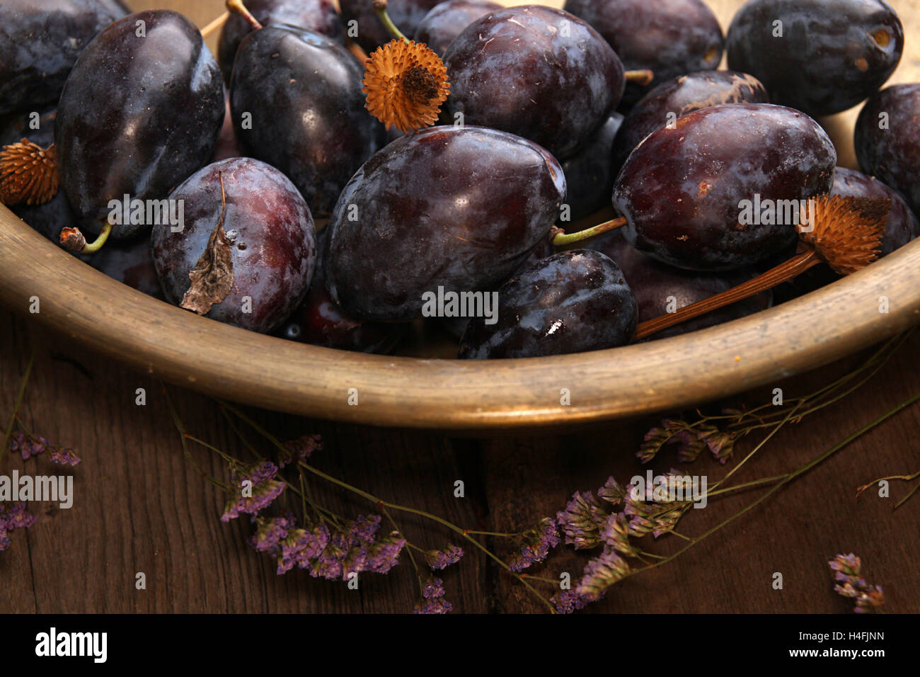 Natürliche Bio-Pflaumen in kupfernen Becken. Rustikalen Landhausstil. Stockfoto