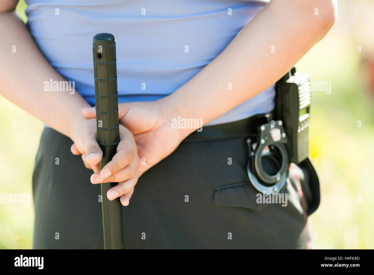 Hände des Polizeibeamten mit einem Schlagstock Tonfa hautnah Stockfoto