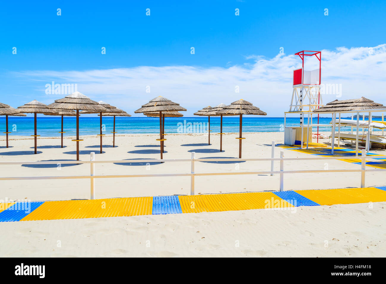 Wanderweg entlang Porto Giunco Sandstrand mit Rettungsschwimmer-Turm und Sonnenschirmen, Insel Sardinien, Italien Stockfoto