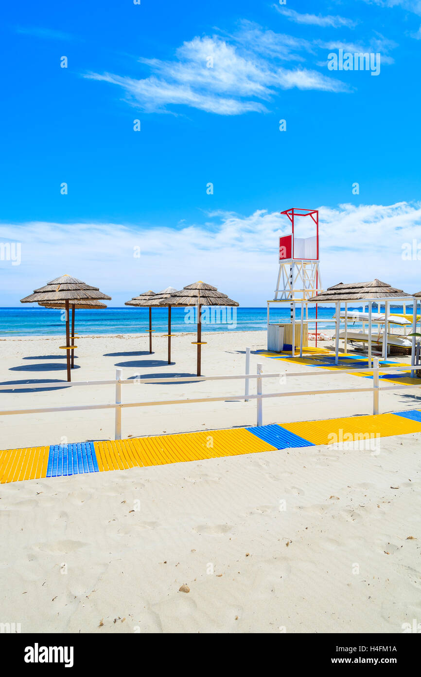 Wanderweg entlang Villasimius Sandstrand mit Rettungsschwimmer-Turm und Sonnenschirmen, Insel Sardinien, Italien Stockfoto