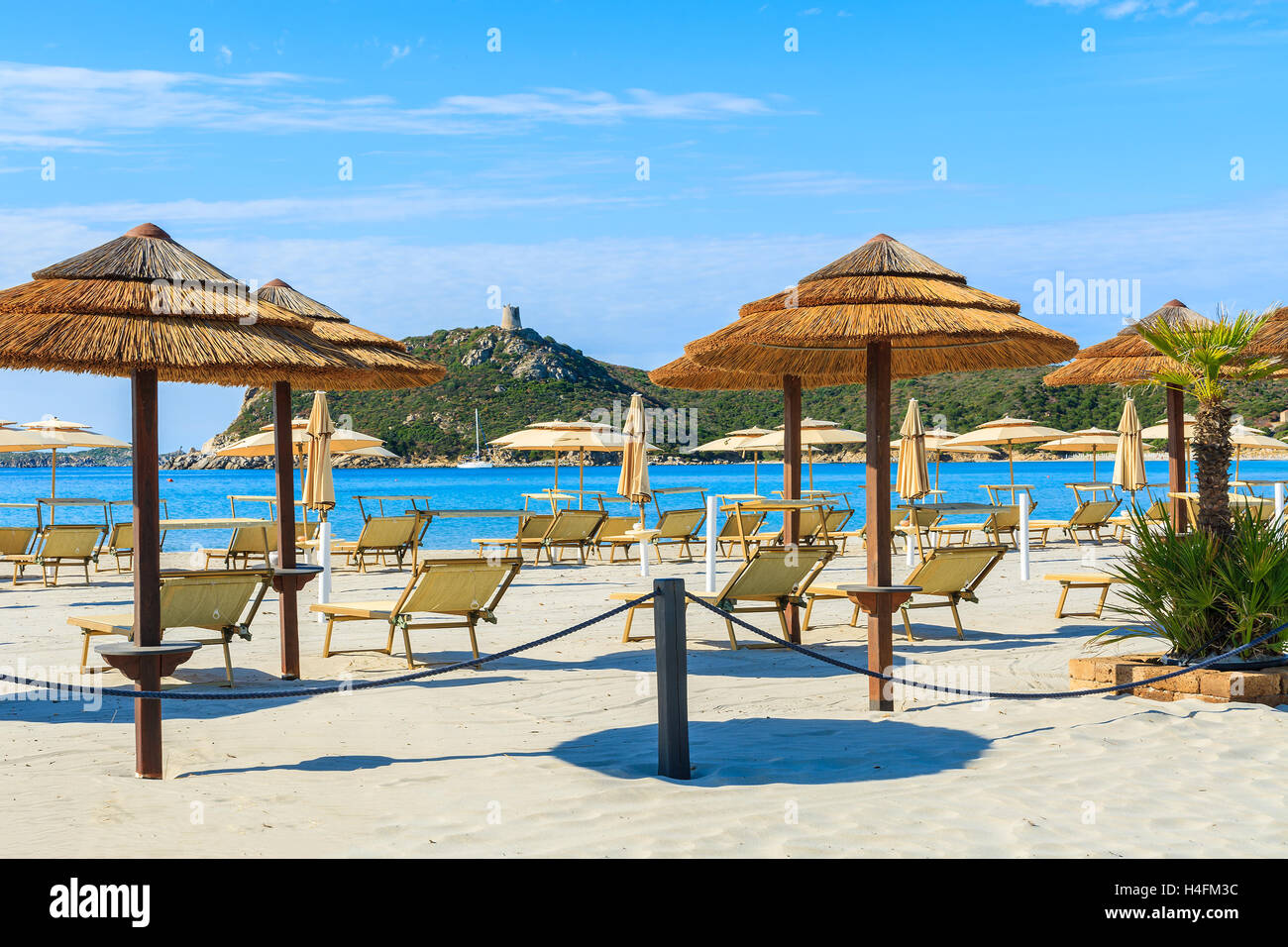 Sonnenschirme und Liegestühle am Strand von Porto Giunco, Insel Sardinien, Italien Stockfoto