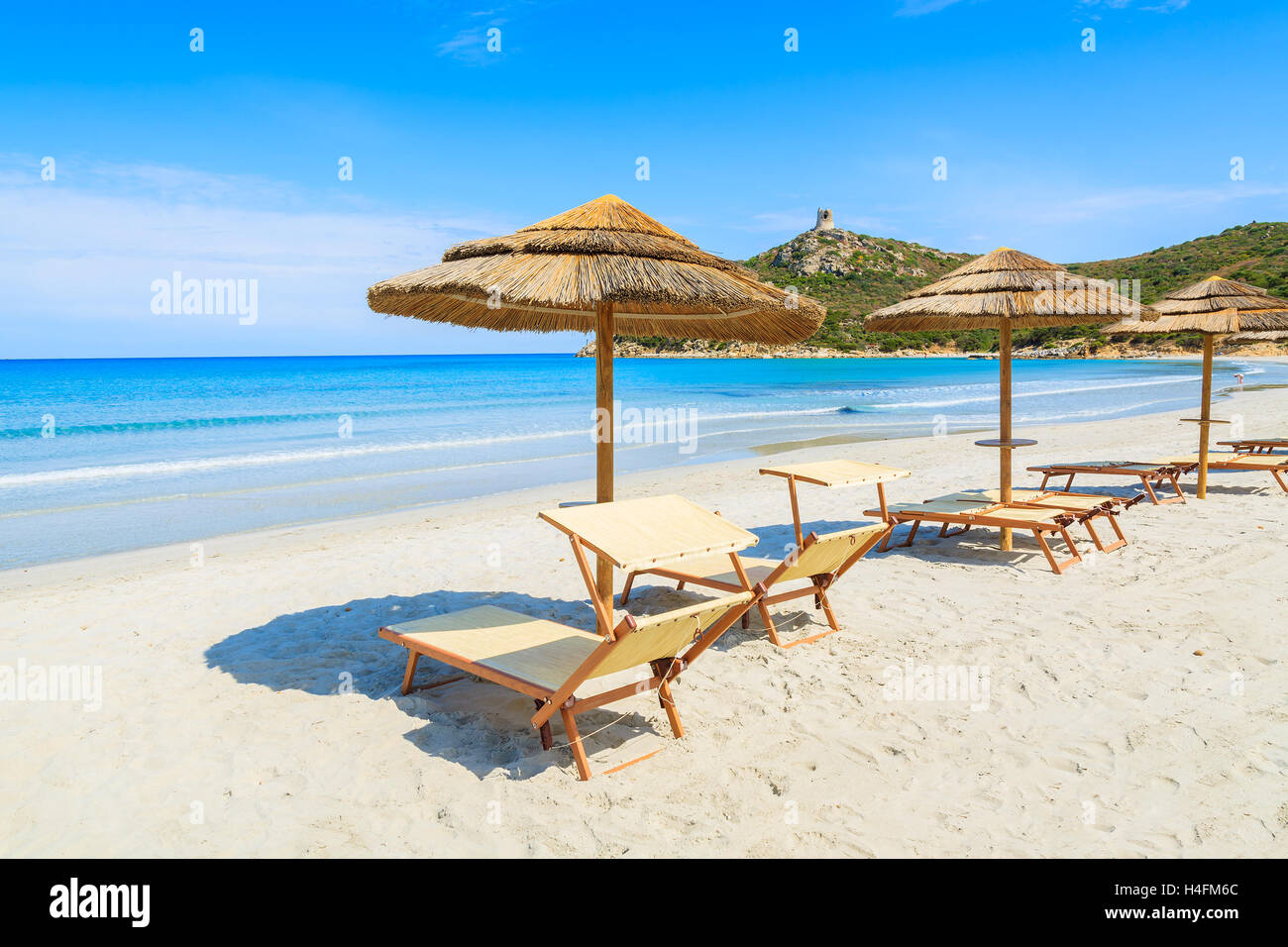 Liegestühle mit Sonnenschirmen am weißen Sandstrand, Porto Giunco Bay, Insel Sardinien, Italien Stockfoto