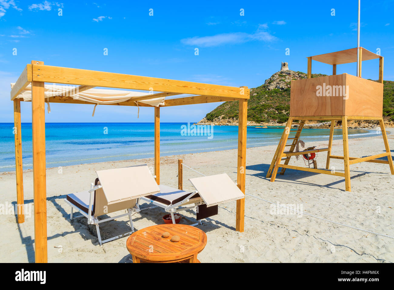Liegestühle und Rettungsschwimmer Turm am schönen Strand von Porto Giunco Bucht, Insel Sardinien, Italien Stockfoto