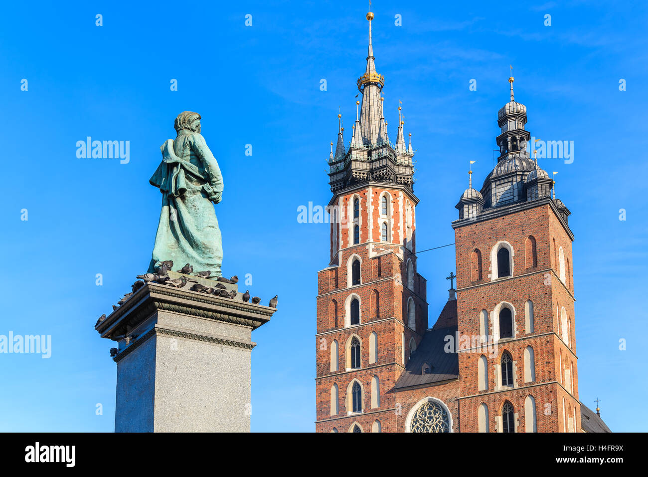 Marienkirche und Adam Mickiewicz Statue gegen blauen Himmel am Hauptmarkt Quadrat von Krakau, Polen Stockfoto