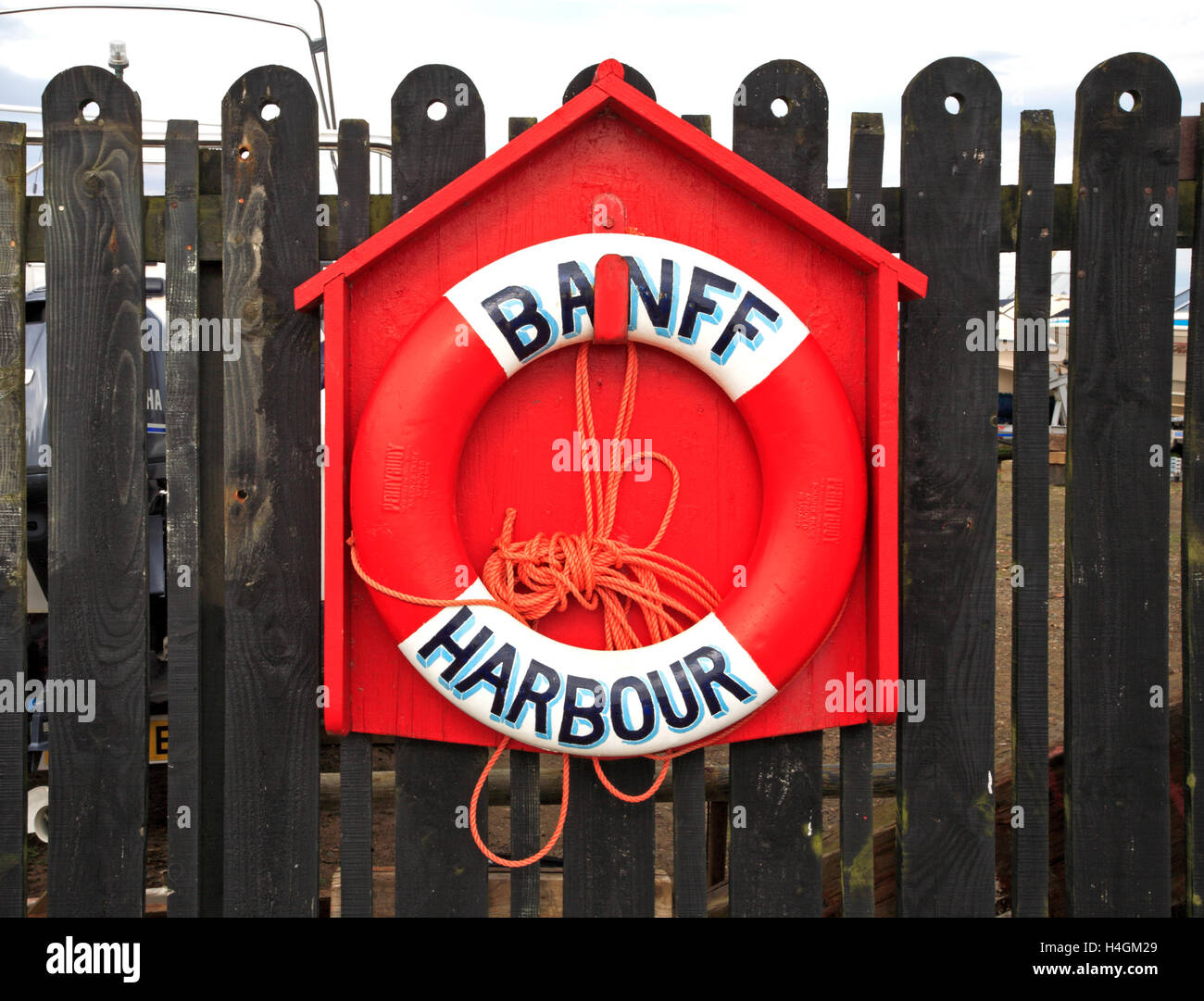 Ein Rettungsring in einem roten Gehäuse durch den Hafen von Banff, Aberdeenshire, Schottland, Vereinigtes Königreich. Stockfoto