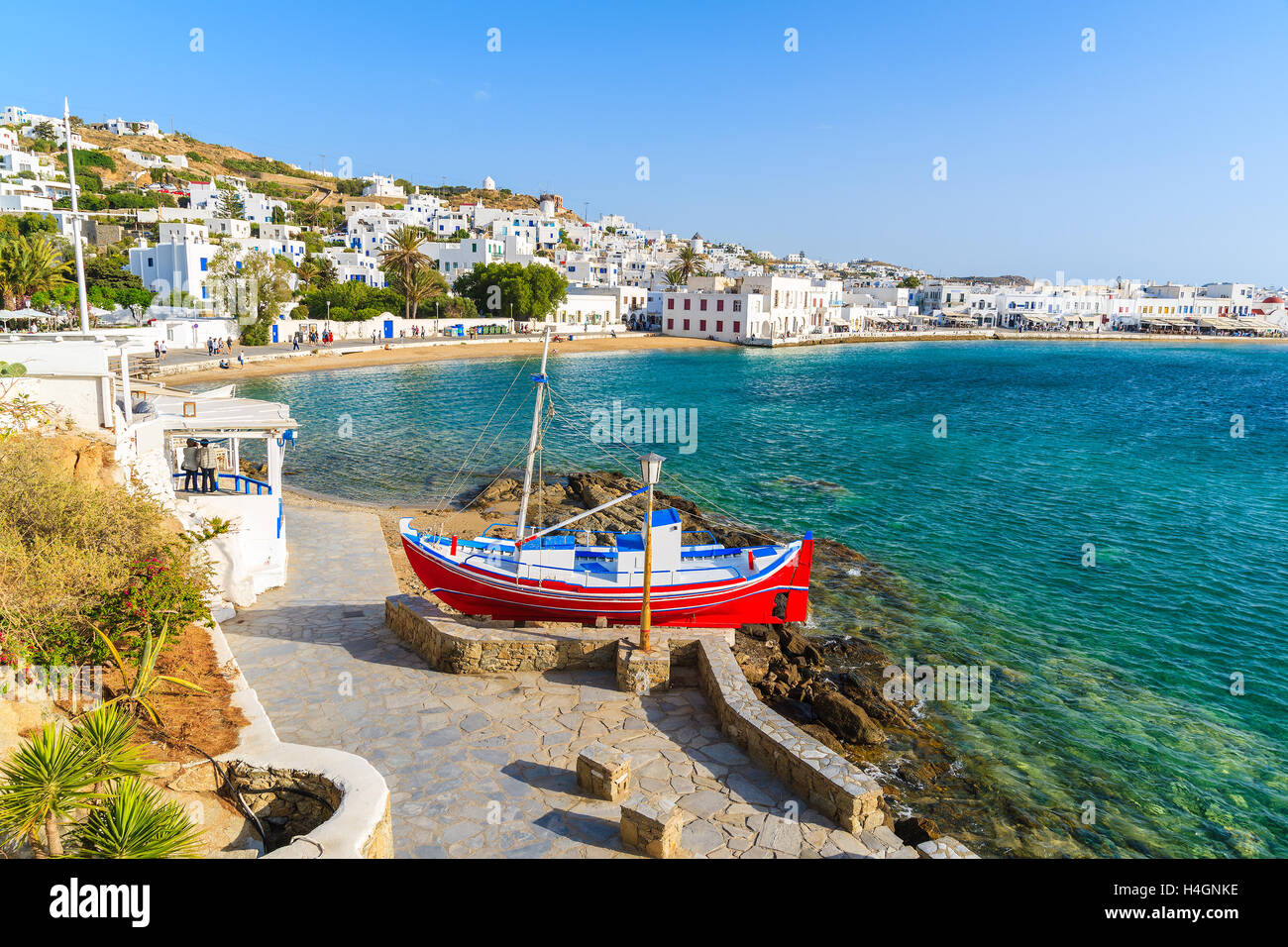 Angelboot/Fischerboot auf Küstenpromenade und Blick auf den schönen Strand mit türkisblauem Meerwasser, Insel Mykonos, Griechenland Stockfoto