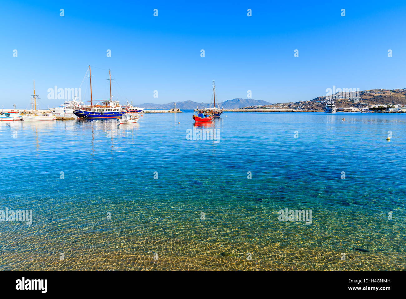 Boote am azurblauen Meer im Hafen von Mykonos, Kykladen, Griechenland Stockfoto