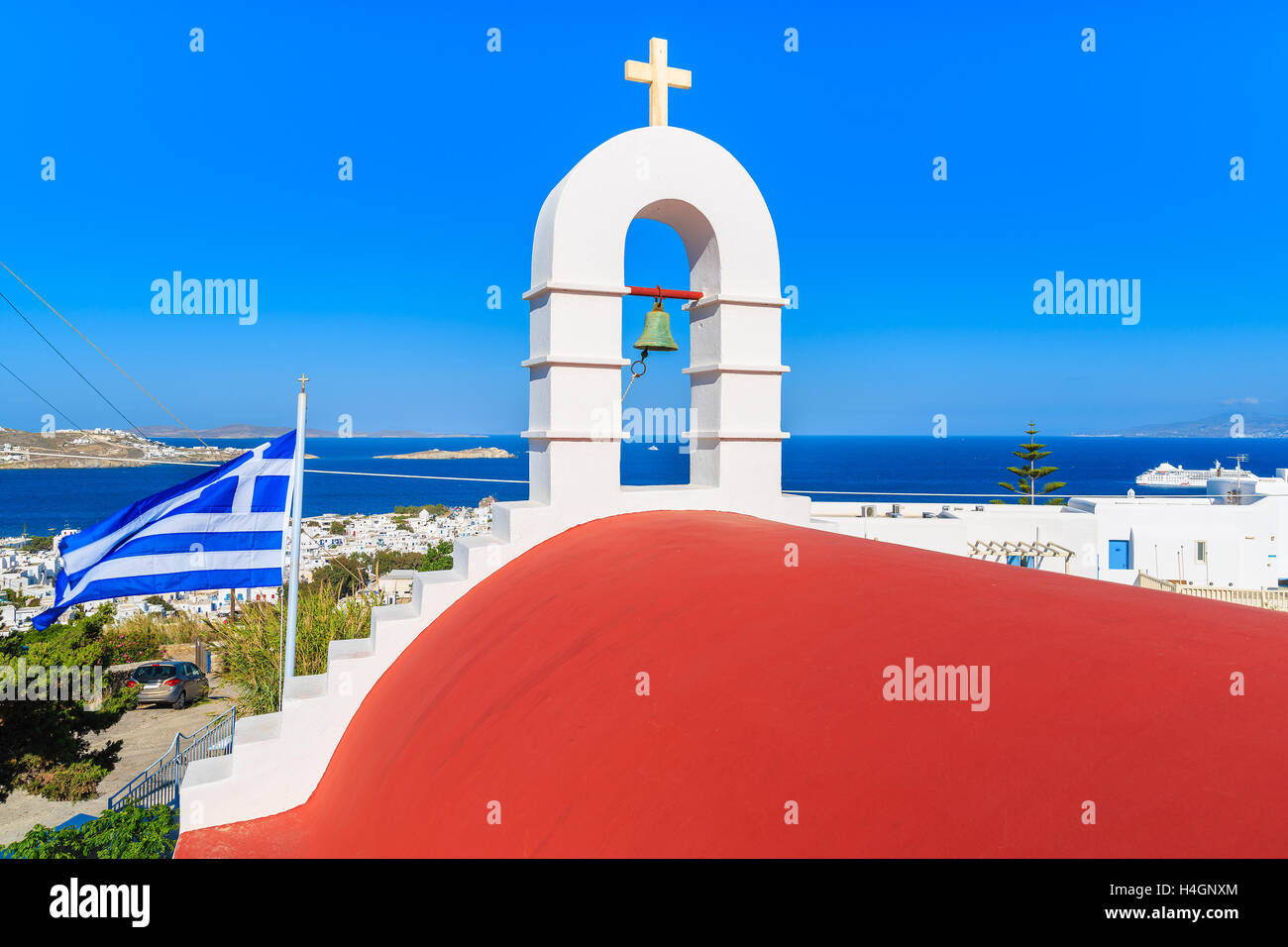 Ein Turm der Kirche mit rotem Dach mit Blick auf Mykonos Bucht mit Hafen, Kykladen, Griechenland Stockfoto