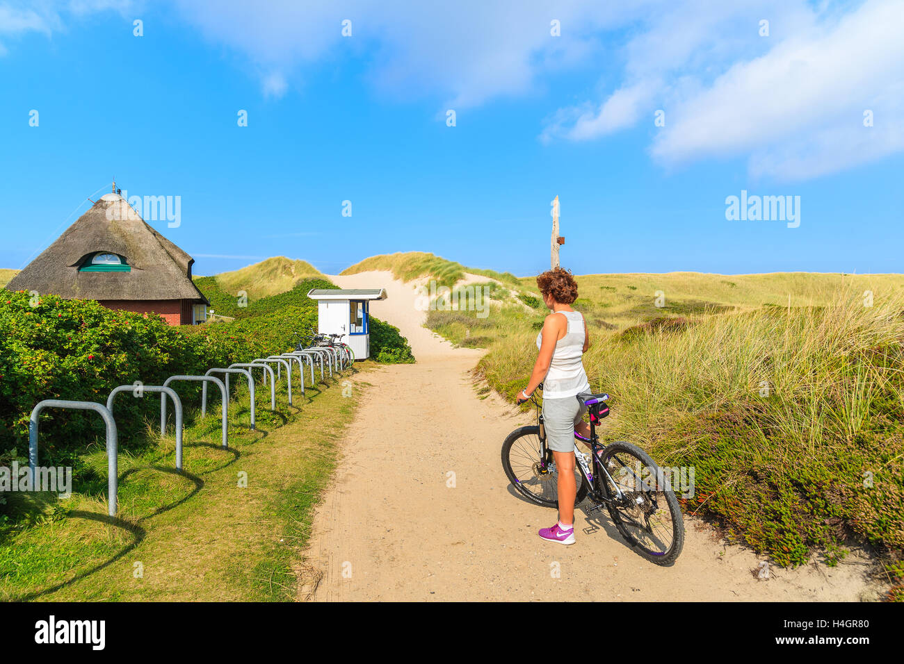 Insel SYLT, Deutschland - SEP 6, 2016: junge Frau auf einem Fahrrad während der Fahrt entlang der Küste von Sylt Insel, Deutschland. Stockfoto
