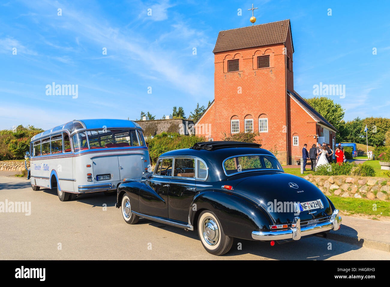 Insel SYLT, Deutschland - 10. September 2016: klassische schwarze Mercedes Benz Limousine und Bus Parkplatz vor einer Kirche in Wenningstedt Stockfoto