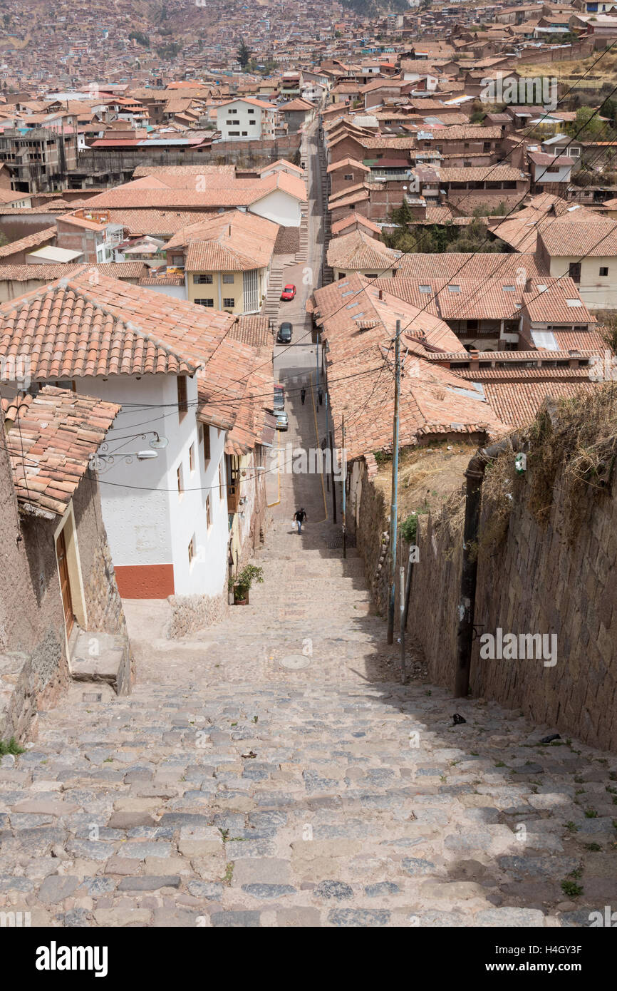 Nach unten gerichtete Blick auf steile Treppen in den Straßen von Cusco, mit der Stadt im Hintergrund Stockfoto