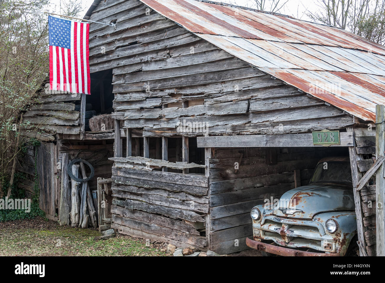 Vintage Scheune mit altem Chevy Truck und neuer amerikanischer Flagge in Lawrenceville, Georgia. (USA) Stockfoto