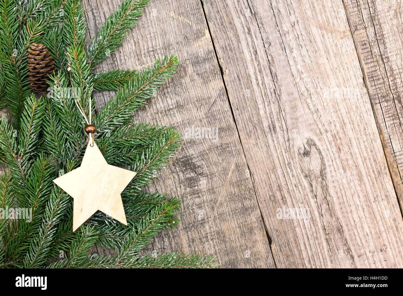 Weihnachtsbaum Tanne Äste mit hölzernen Stern auf verwitterten Brett Hintergrund Stockfoto