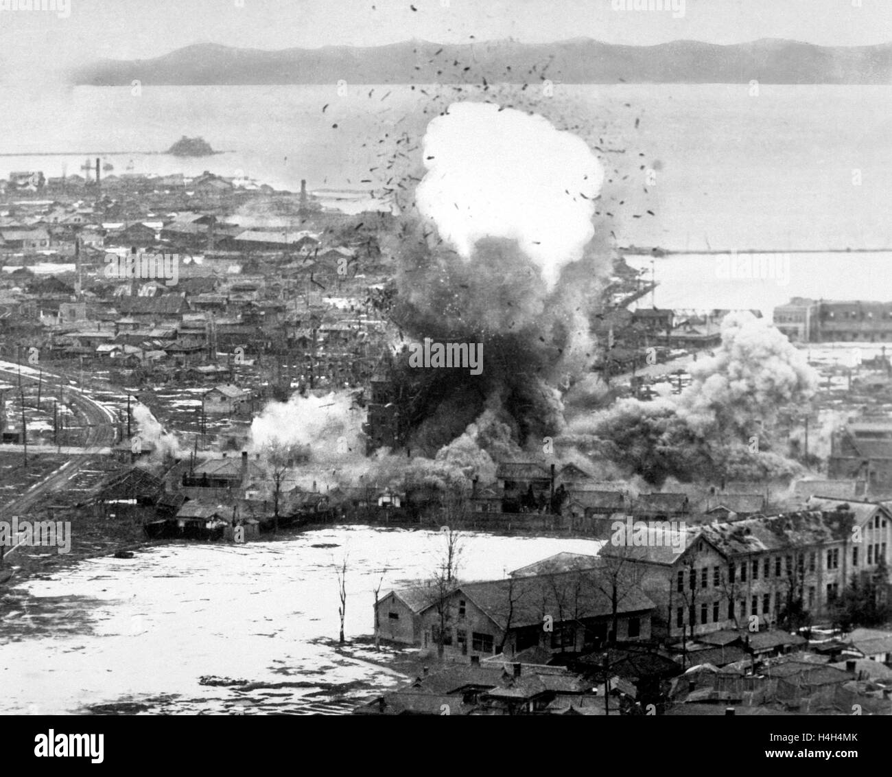 US Air Force B-26 Invader Bomber Para-Abbruch Bomben auf Lager und dock-Einrichtungen während des Koreakrieges 1. Mai 1951 in Wonsan, Nordkorea. Stockfoto