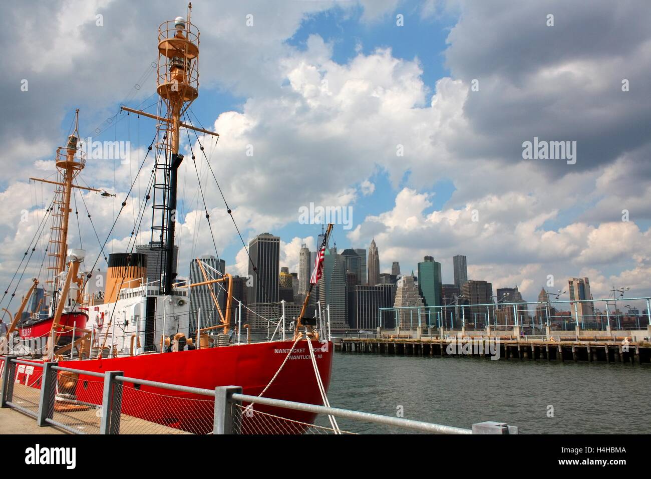 Rote Schiff Boot angedockt am Pier 6 im Brooklyn Bridge Park mit Blick auf Downtown Manhattan Wolkenkratzer, New York. Stockfoto