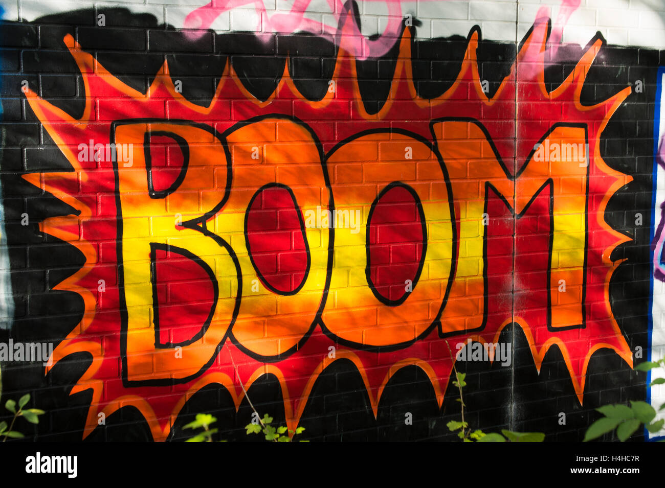 Boom! Rot Graffiti auf schwarze Wand Stockfoto