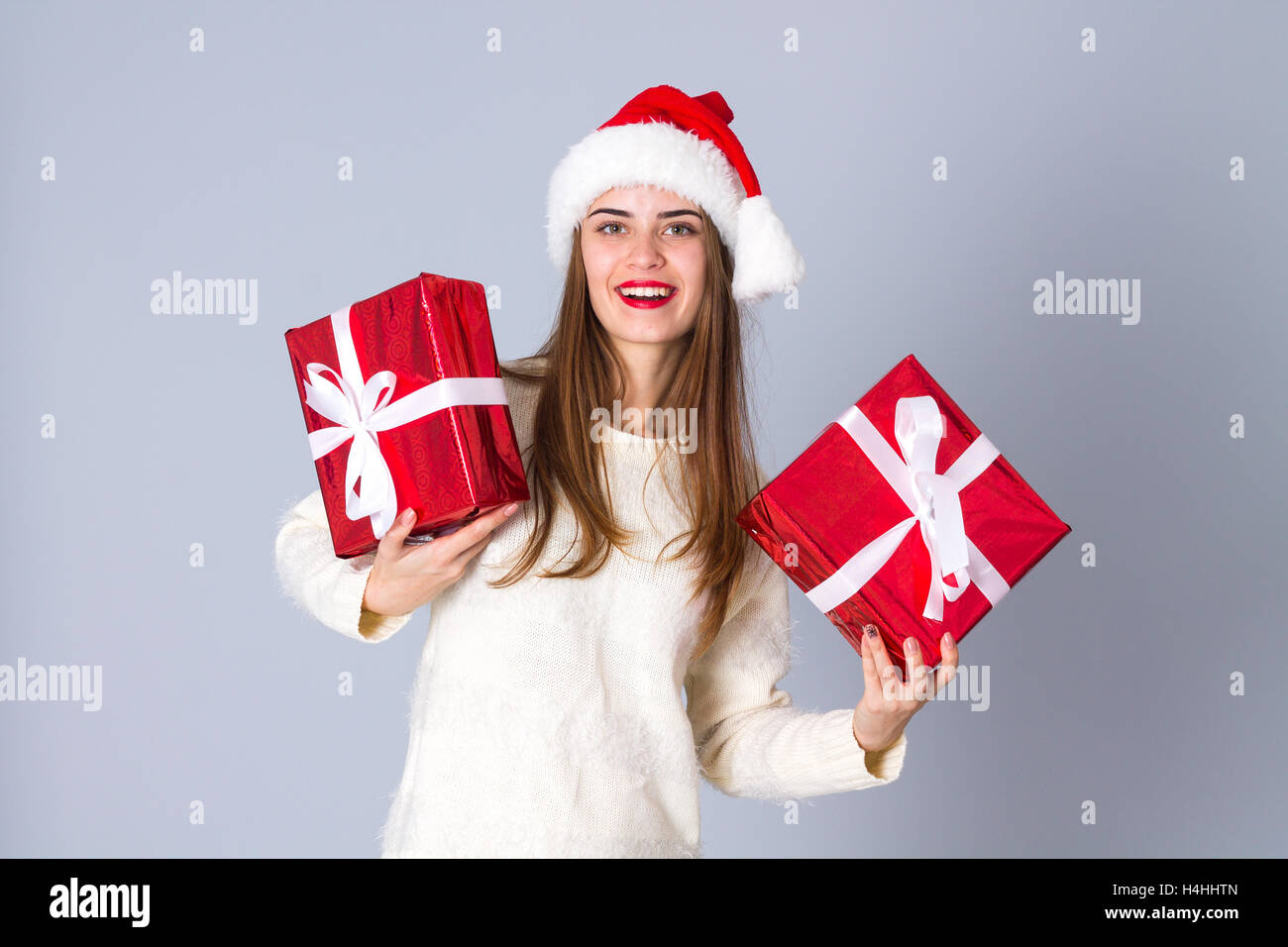 Frau in rot Weihnachtsmütze hält Geschenke Stockfoto