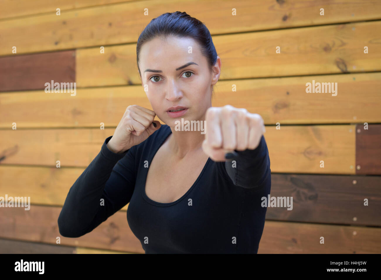 Junge hübsche Frau Fitnessübungen während Training Boxtraining am hölzernen Palettenstellplatz Hintergrund Stockfoto