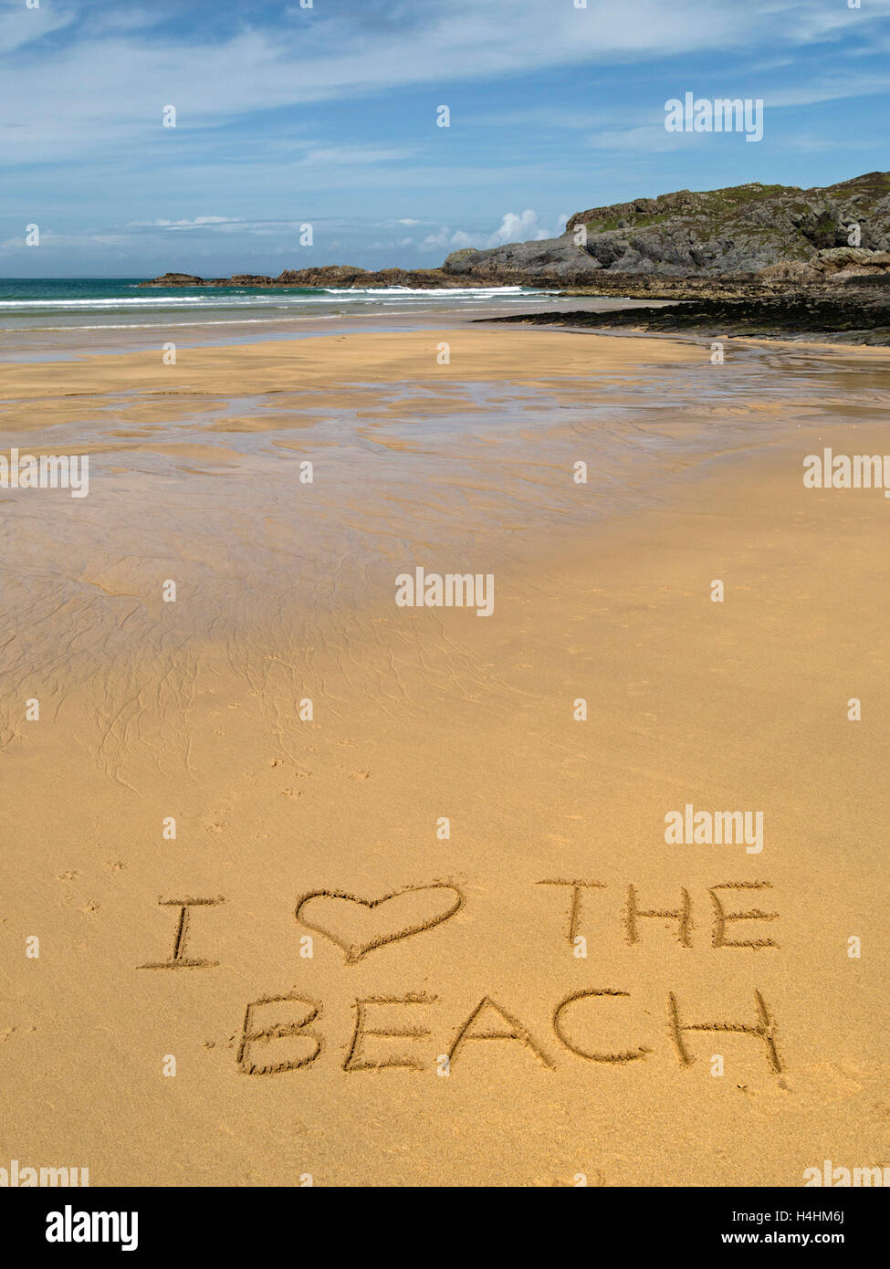 Die Worte "Ich liebe den Strand" in goldenen gelben Sand der abgelegenen schottischen Strand geschrieben. Stockfoto