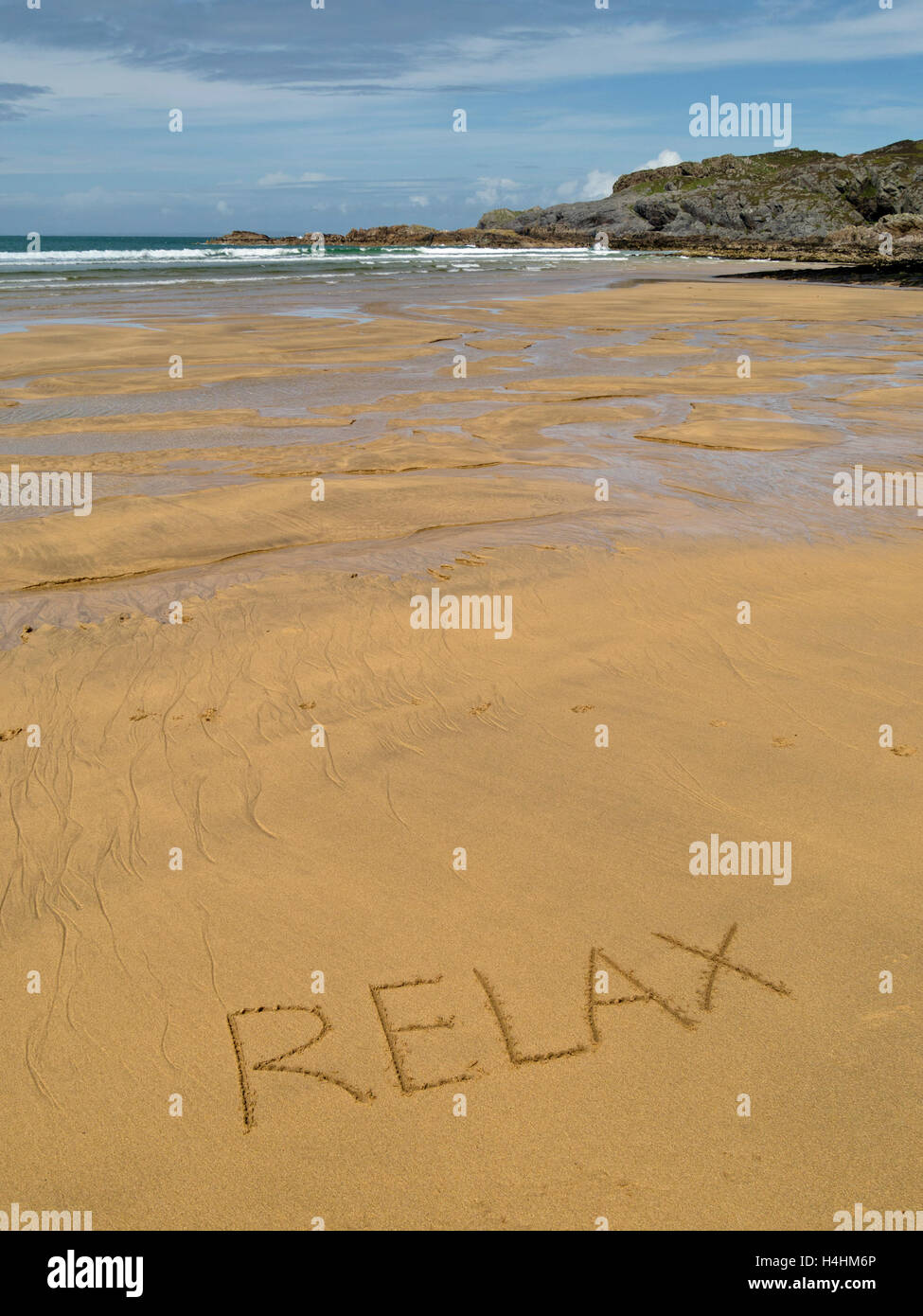 Das Wort "Relax" in goldenen gelben Sand der abgelegenen schottischen Strand geschrieben. Stockfoto