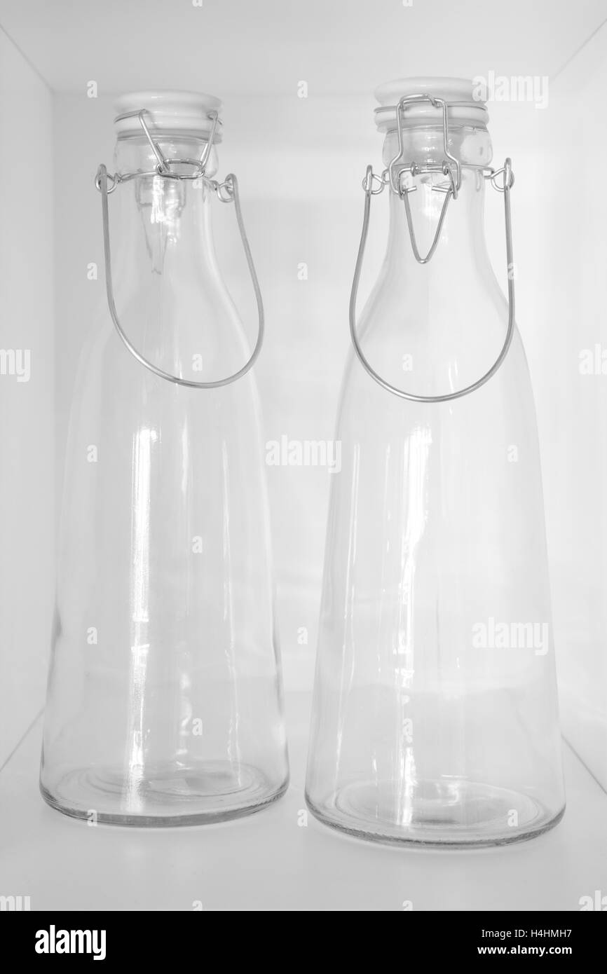 Leeres Kristallflaschen in einem Schrank mit weißem Hintergrund. Vertikal Stockfoto