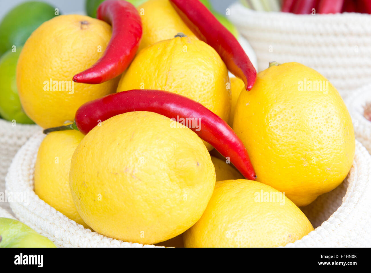 die Zitronen und Chilischoten in einem geflochtenen Korb Nahaufnahme Stockfoto