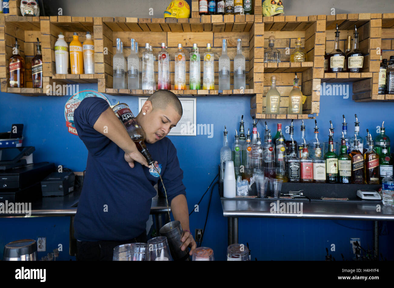 Eine jonglierende Barkeeper Gießen einen Drink und eine Flasche Schnaps auf seiner Hand & Unterarm ausgeglichen. Auf der Promenade in Coney Island. Stockfoto
