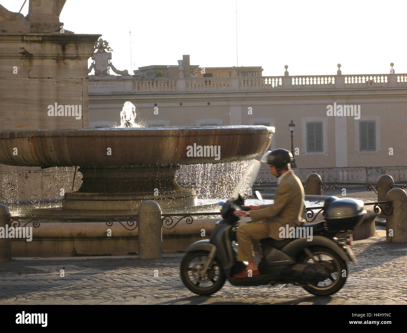 Mann auf einem Motorrad an einem sonnigen Tag, Brunnen, Rom, Italien. Stockfoto