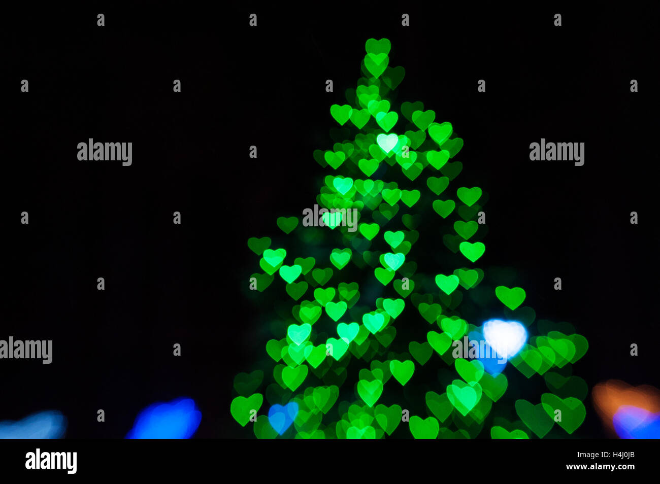 schöne grüne Bokeh in Form von Weihnachtsbaum auf schwarzem Hintergrund Stockfoto