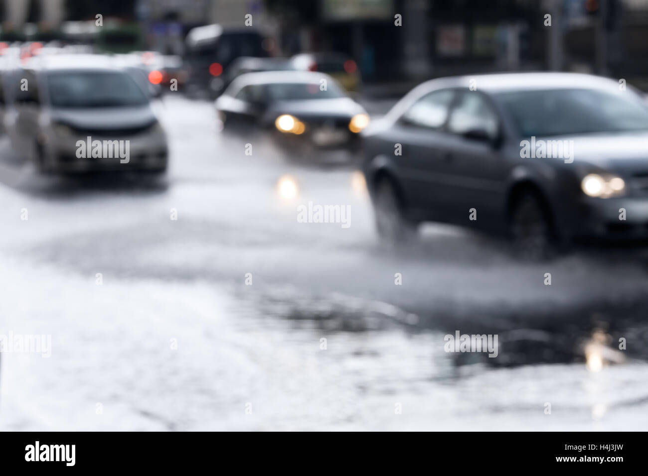 Pkw-Verkehr auf nasser Fahrbahn nach Regenguss. Verschwommene Sicht durch Autofenster. Stockfoto