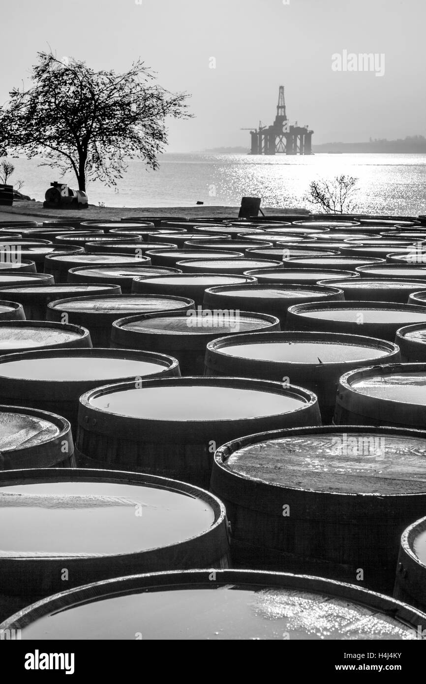 Schottische Ölindustrie Bohranlage im Hafen & Scotch Whisky Fässer Dalmore große Brennerei, Invergordon, Cromarty Firth im Norden von Schottland, Großbritannien. Stockfoto