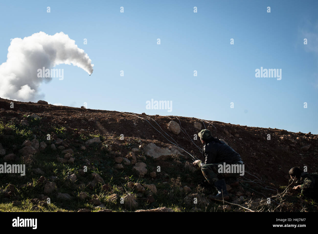Raketenfeuer - 16.01.2013 - Syrien / Aleppo / Kwiriss Flughafen - ein Kämpfer der Brigade Abo Baker (freie syrische Armee) nimmt Zuflucht, wie er feuert eine Rakete auf syrischen staatlichen Truppen verteidigen die Kwiriss Militärflughafen in Al-Bab in der Nähe von Aleppo.   -Edouard Elias / le Pictorium Stockfoto