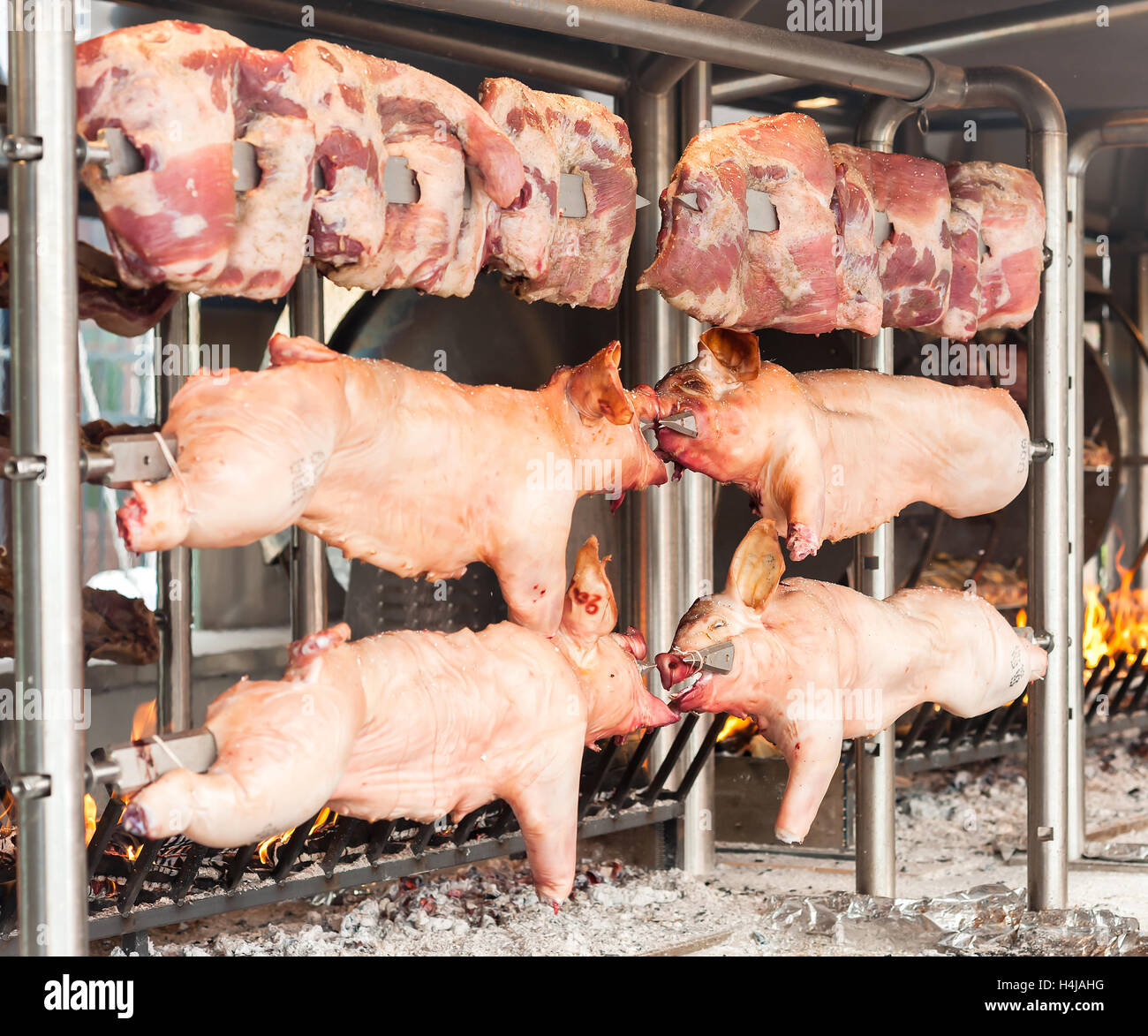 Schlachtkörper von Schweinefleisch und anderen Fleisch am Spieß zubereitet. Kochen am Grill und Feuer. Stockfoto