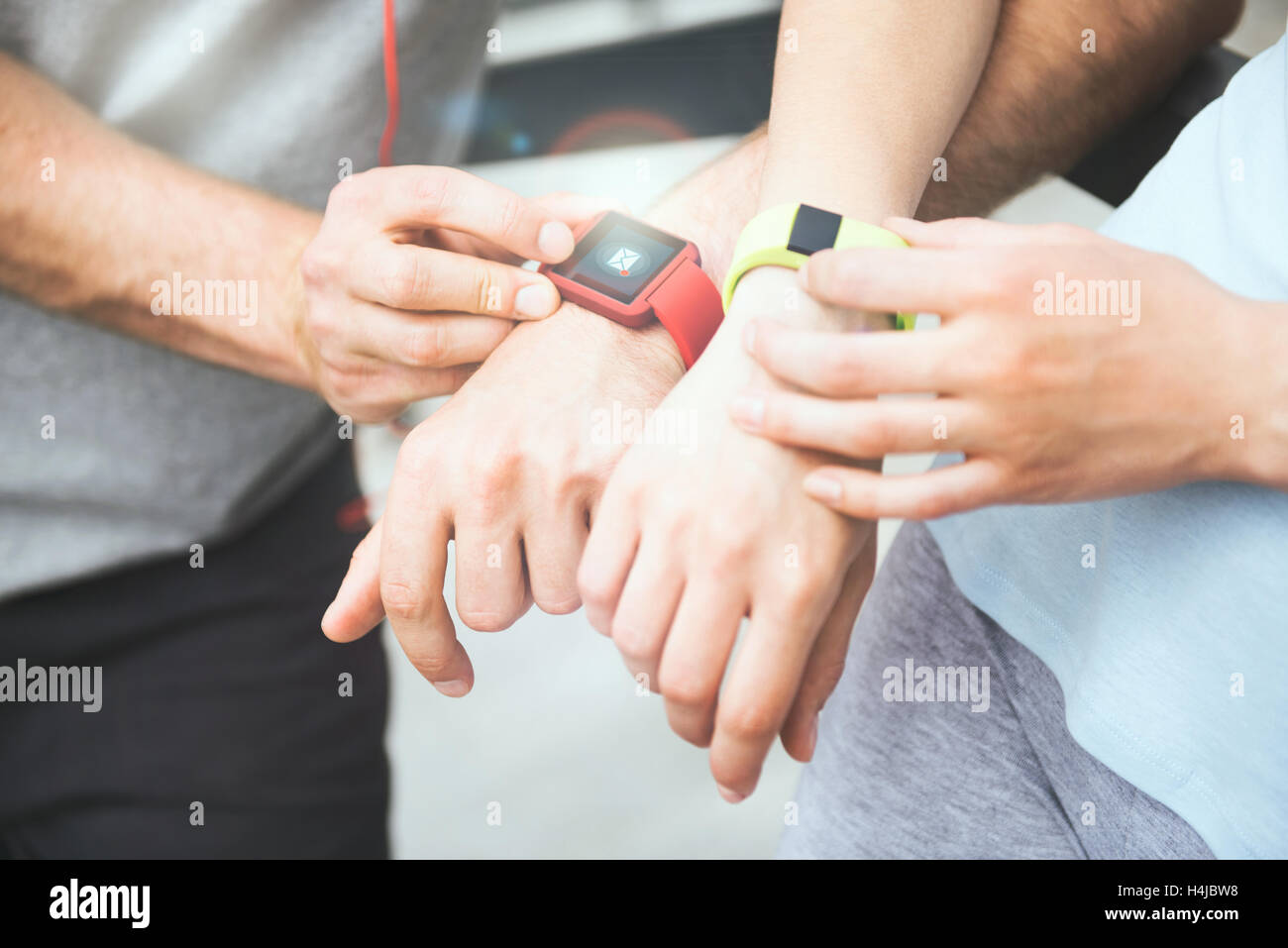 Sportliches Paar teilen Trainingsdaten aus ihrer Smartwatches. Stockfoto