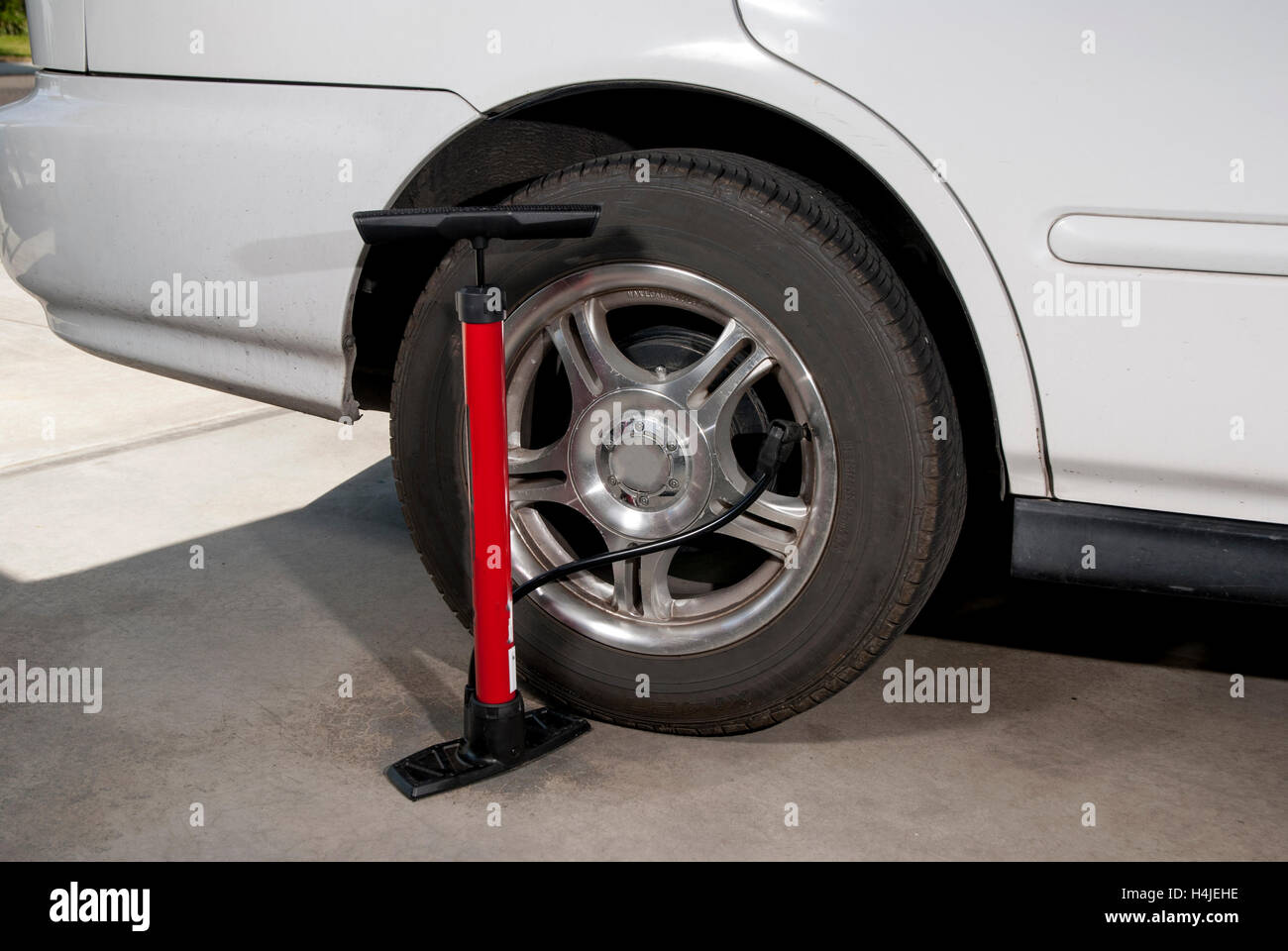 Pkw-Reifen mit Fahrradpumpe angeschlossen, um es Stockfoto